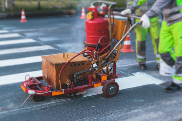 Process of making new road surface markings with a line striping machine, workers improve city infrastructure, demarcation marking of pedestrian crossing with a hot melted paint on asphalt pavement proceso de hacer nuevas marcas de superficie vial con una máquina de rayado de líneas, los trabajadores mejoran la infraestructura de la ciudad, la demarcación del paso de peatones con pintura derretida en caliente en el pavimento de asfalto