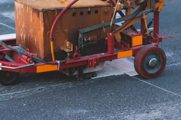 istock Process of making new road surface markings with a line striping machine, workers improve city infrastructure, demarcation marking of pedestrian crossing with hot melted paint on asphalt pavement 1500362655
