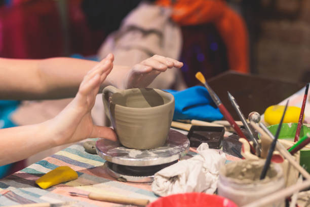 istock Pottery lesson master class for kids children, process of making clay pot on pottery wheel, potter wet hands creating ceramic crockery handcrafts, ceramist molding jar or vase 1500363800