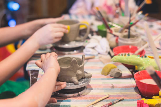 istock Pottery lesson master class for kids children, process of making clay pot on pottery wheel, potter wet hands creating ceramic crockery handcrafts, ceramist molding jar or vase 1500363801