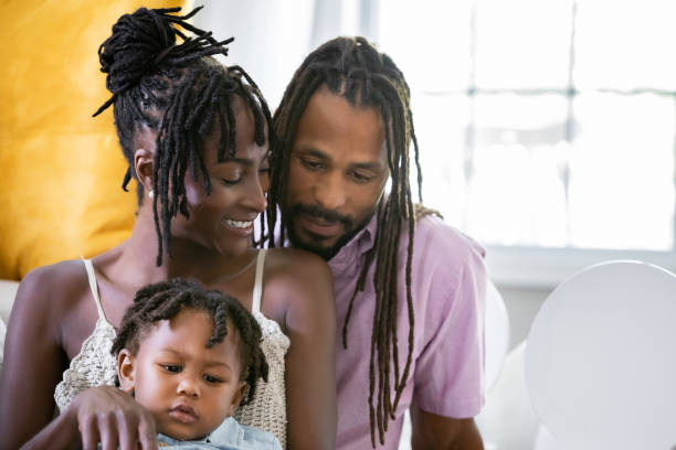 Beautiful young mother smiles while spending time with her husband and son at home