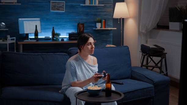 istock Focused determined woman playing video game late night 1500375042