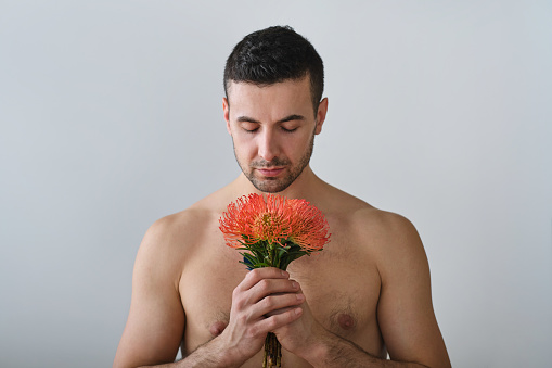 front view portrait of a shirtless carefree man enjoying a poetic moment with closed eyes on a white background
