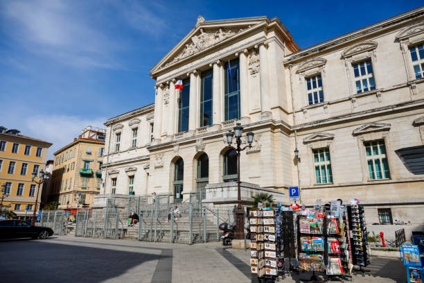 Nice, France - April 21, 2023: View of the facade of the Palace of Justice, which is located in the Old Town. In front of the palace there is a square where there are racks of a trade stall visible