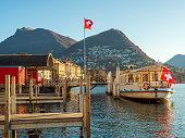 seeufer-in-lugano-schweiz-mit-einer-f%C3%A4hre-die-am-dock-vor-anker-liegt.jpg?b=1&s=170x170&k=20&c=pLej4V82Q9e0G3fHcj0s0QAhVf61a7mTfBfoZxOZX6A=