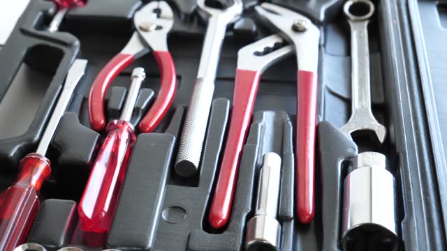 Opened plastic case with tools for technician arranged in separated slots in rotation 4K video