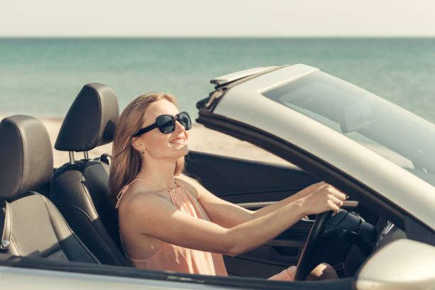 istock Young woman drive a car on the beach 1500392280