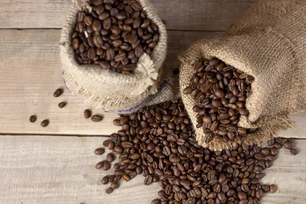 Fresh coffee. Coffee beans in bags on a wooden background. View from above. Copy space. Banner