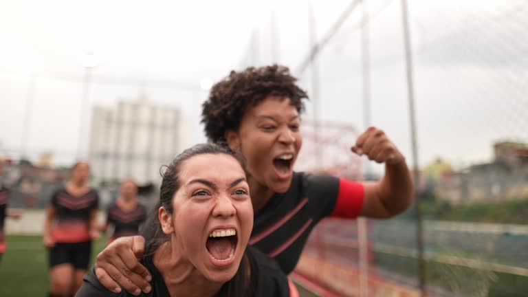 Female soccer players celebrating on the soccer field