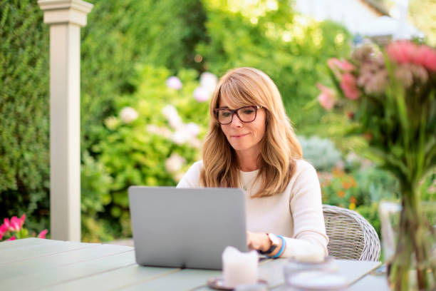 istock Mid aged businesswoman using laptop at home 1500403517
