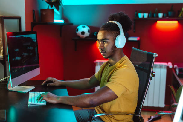 istock An urban African American man is sitting at the table and using a desktop computer 1500413545