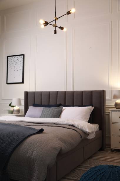 istock Comfortable bed with pillows and bedding in stylish room. Interior design 1500413722