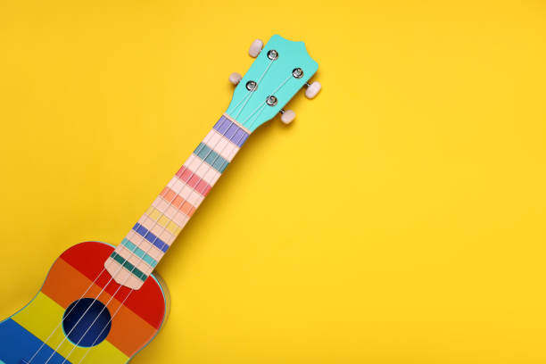 istock Colorful ukulele on yellow background, top view with space for text. String musical instrument 1500413753