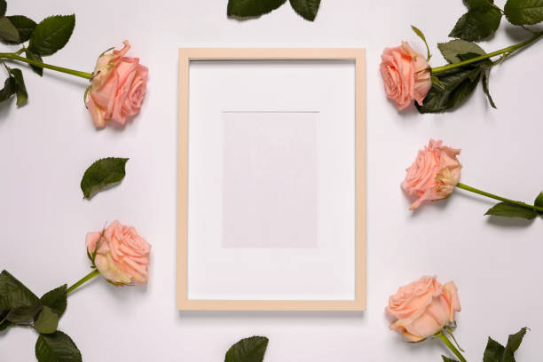 istock Empty photo frame and beautiful flowers on white background, flat lay. Space for design 1500413902