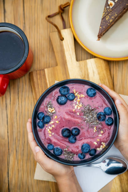 istock Child's hands holding blueberries smoothie bowl 1500414127