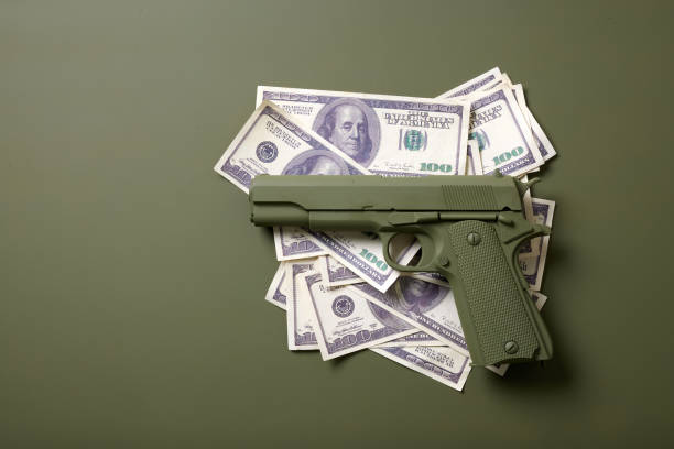 pistolet vert avec de l’argent sur fond vert - currency crime gun conflict photos et images de collection