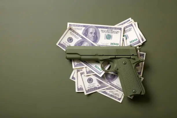 Photo of green gun with money on a green background
