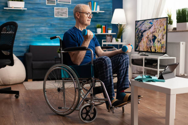 istock Invalid pensioner in wheelchair training body muscles persistence using gym dumbbells 1500415764