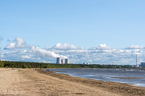 Nuclear power plant on the shore of the Gulf of the Sea. Beaches seashore against the background of floating cooling towers of a nuclear power plant