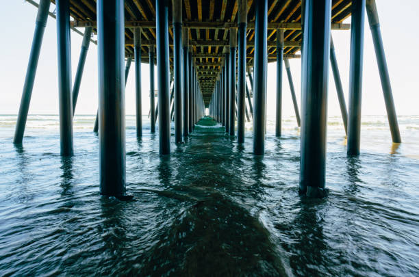 istock Under the pier. A long wooden pier, and ocean waves, a dramatic scene 1500420279
