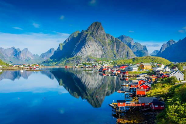riflesso perfetto del villaggio reine sull'acqua del fiordo nelle isole lofoten, norvegia - house scandinavian norway norwegian culture foto e immagini stock