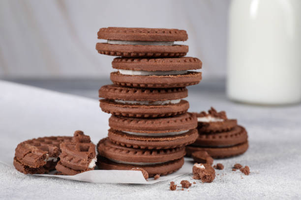 istock Tasty chocolate sandwich cookies with cream on light grey table, closeup 1500420624