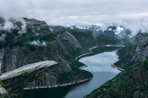 The amazing Trolltunga scenic spot, famous rock formation in Norway, moody landscape