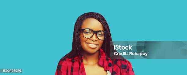 Portrait Of Young Smiling African Woman Wearing Eyeglasses Isolated On Blue Background Stock Photo - Download Image Now