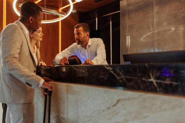 istock Hotel receptionist talking with new guests about booking room 1500427045
