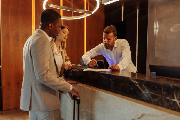 istock Hotel receptionist showing contract to new guests 1500427141