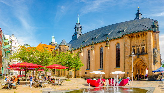 Chemnitz, Saxony, Germany, June 21, 2022: Outdoor street cafÃ© and restaurants with umbrellas in the historic downtown of Chemnitz, at blue sky and sunny summer day
