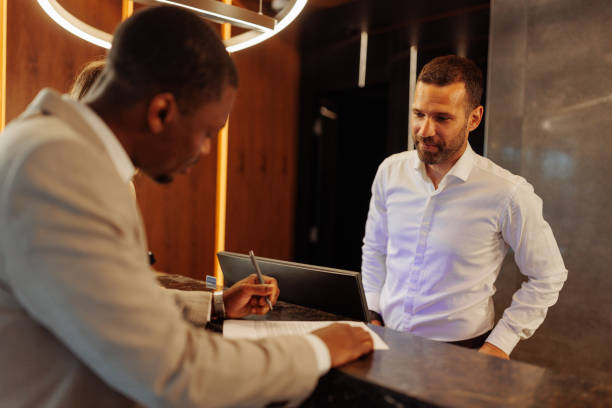 istock Hotel receptionist waiting for guest to sign contract 1500431955