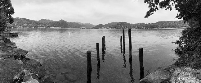 Landscape with a semi submerged old wooden pier, along the shores of Lake Orta (Piedmont, Northern Italy), summertime.