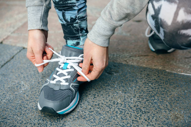 istock Woman runner tying her sneakers laces to training 1500435360