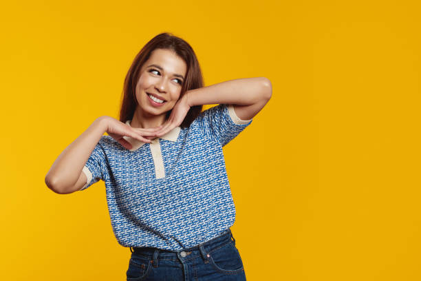 istock Happy young girl smiling while holding hands under the chin, looking at free empty space for text 1500439332
