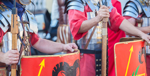 Reenactors as roman legionaries in formation. Hands holding pila and javelins