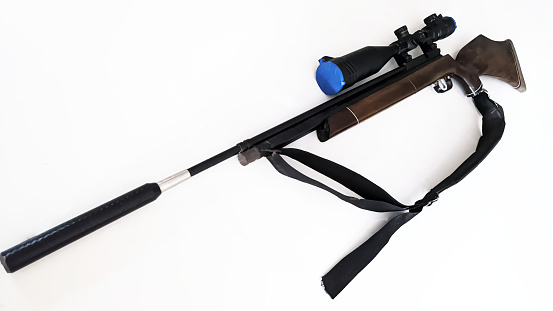 A wooden-handled air rifle with a large telescope on a white background