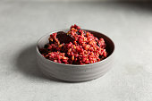 Risotto with beetroot on concrete background. Close up