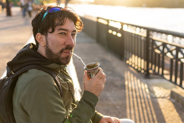 istock Latin man enjoying the sunset at the river while drinking mate 1500449440