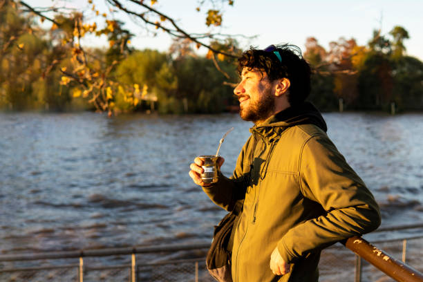 istock Latin man enjoying the sunset at the river while drinking mate 1500449465