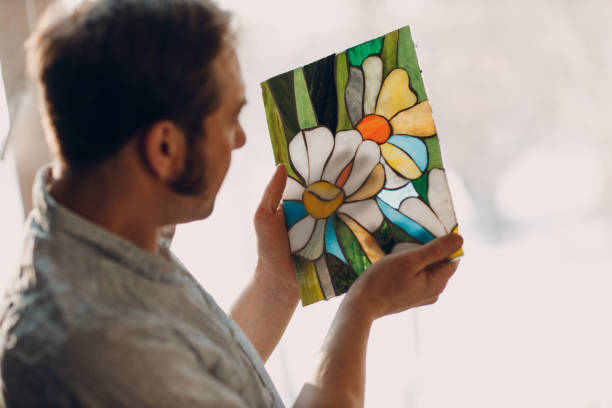 Restorer master male checking stained glass window project.