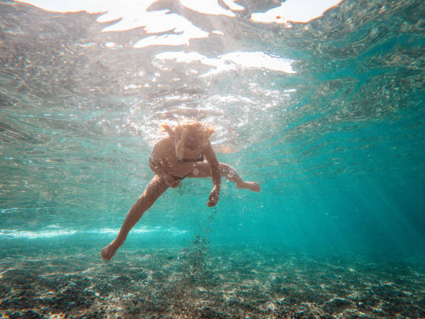 istock Little Boy Floating Underwater And Playing With Sand 1500450018