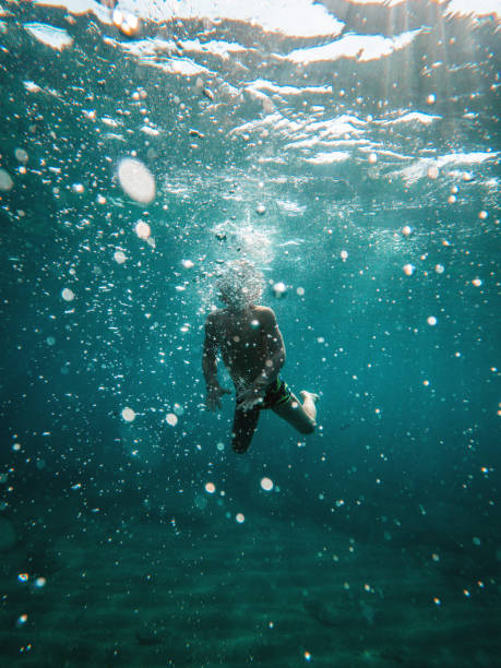 istock Happy Young Boy Swimming Underwater And Doing Bubbles 1500450023