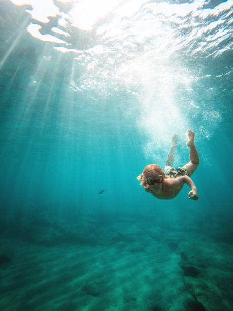 istock Young Caucasian Kid Exploring Underwater With Goggles 1500450032