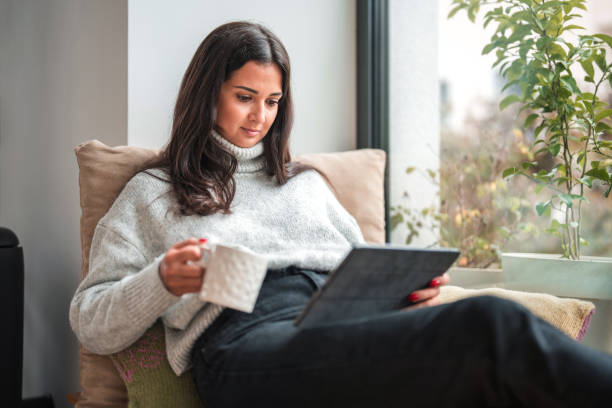 istock Beautiful Young Caucasian Female Reading Emails And Working From Home, Using A Digital Tablet 1500450069