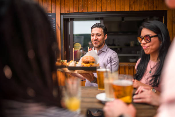 istock Helpful Man Bringing Over Food to the Table 1500450102