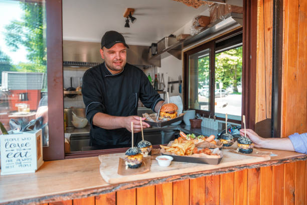 istock Caucasian Cook Handing Over Hamburger to Client 1500450116