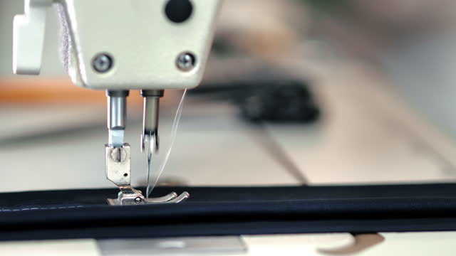 Seamstress woman hand sews textile details use electric sewing machine thread dressmaking closeup