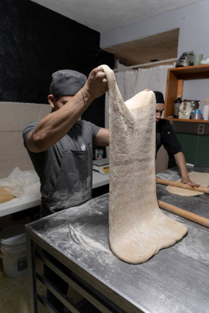 istock A young Hispanic baker is stretching some butter dough to make cinnamon rolls 1500460763