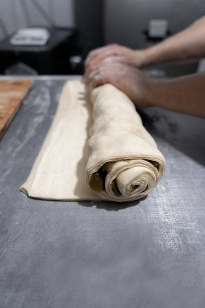 istock A young Hispanic baker is rolling figs with butter dough to make cinnamon rolls 1500461559